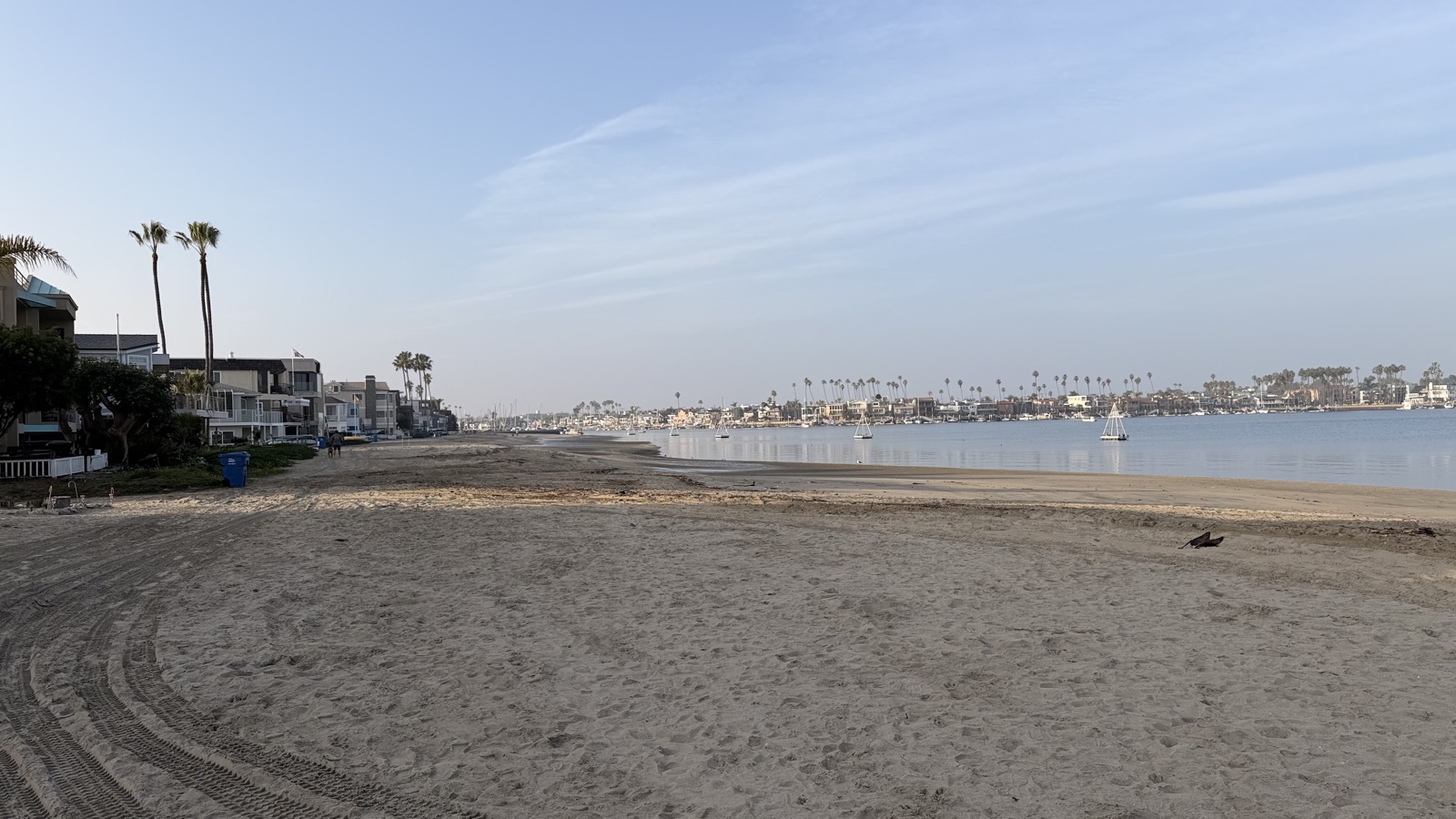 Naples Island — Long Beach coastal peninsula with sandy beach, palm trees, sailboats, and waterfront homes. Represented by Kiri Suykry, Keller Williams Huntington Beach.