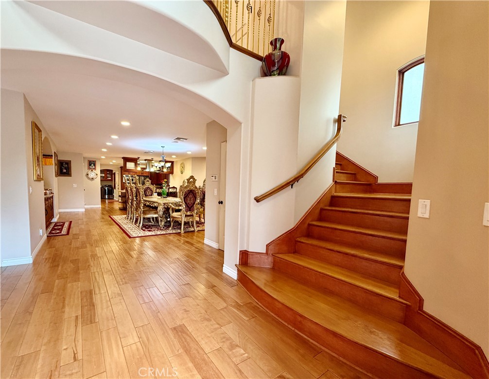 Light-filled main hall at 116 Termino with curved staircase and hardwood floors