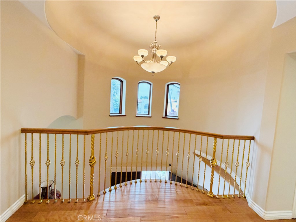 Rotunda landing at 116 Termino with chandelier and arched windows